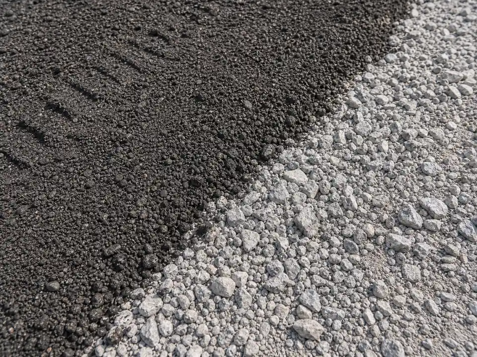 Close-up of dark asphalt millings meeting light crushed gravel